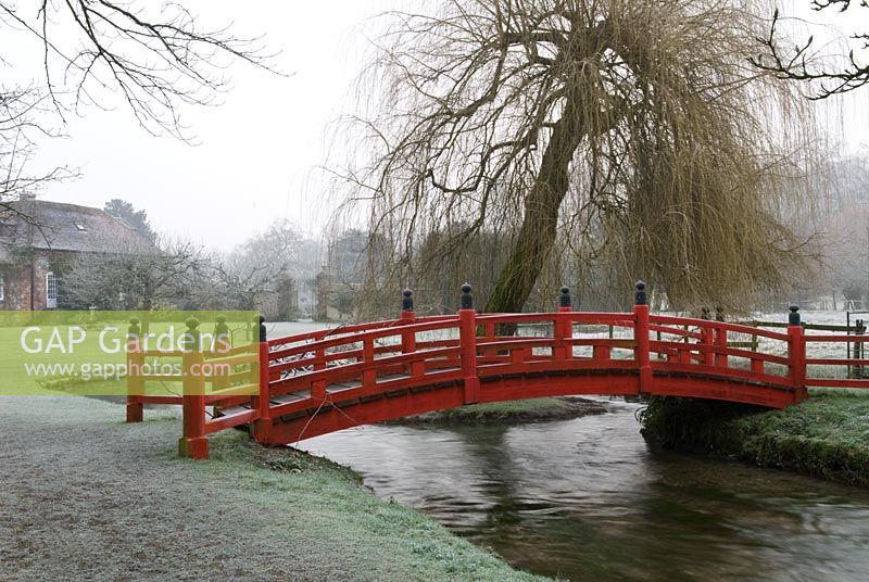 Rote japanische Brücke über den Fluss im Frost, Heale House Gardens, Wiltshire