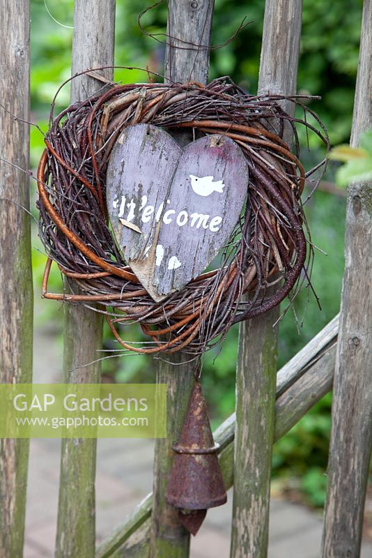 Rustikales Willkommensschild und rostige Glocke am Holztor - Scheper Town Garden
