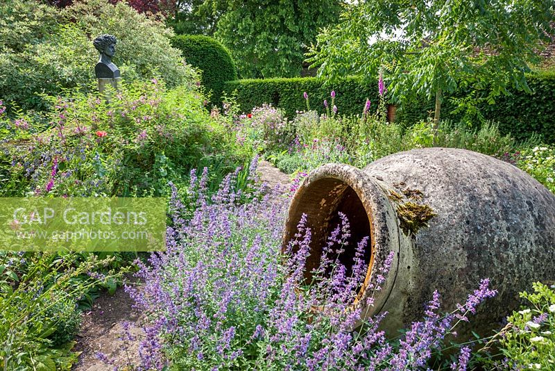 Großer Terrakottatopf und Büste von Leon Krier im Mittelmeergarten, Highgrove, Juli 2013. Der Garten enthält Lavendel, Rosmarin und Zistrosen mit einer Spitzenblütezeit im Juni.