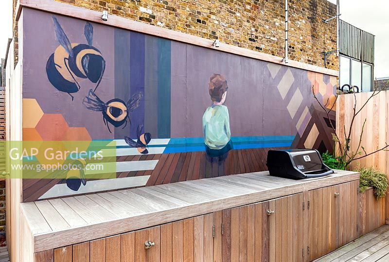 Gemaltes Wandbild von Lauren Mele hinter dem Grillbereich des Londoner Dachterrassengartens