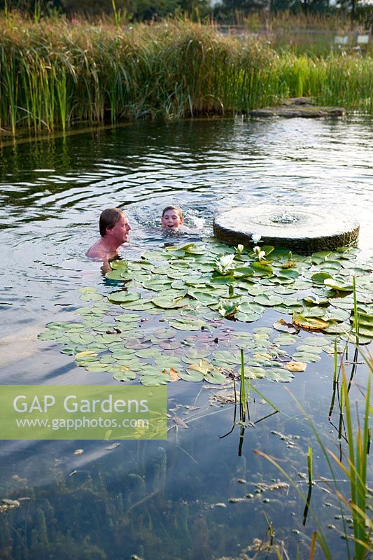 Mann und Junge schwimmen im 'natürlichen' Schwimmbad
