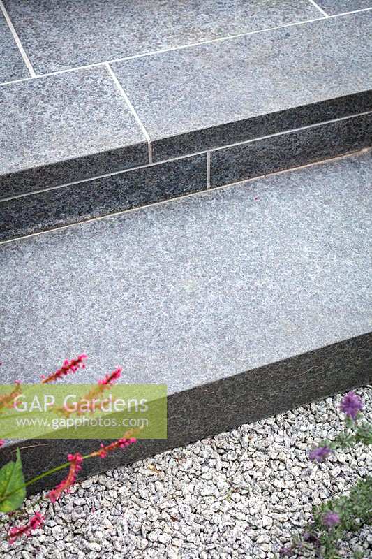 Schritte in strapazierfähigen schwarzen Basaltfliesen. Gartengestaltung von John Davies.
