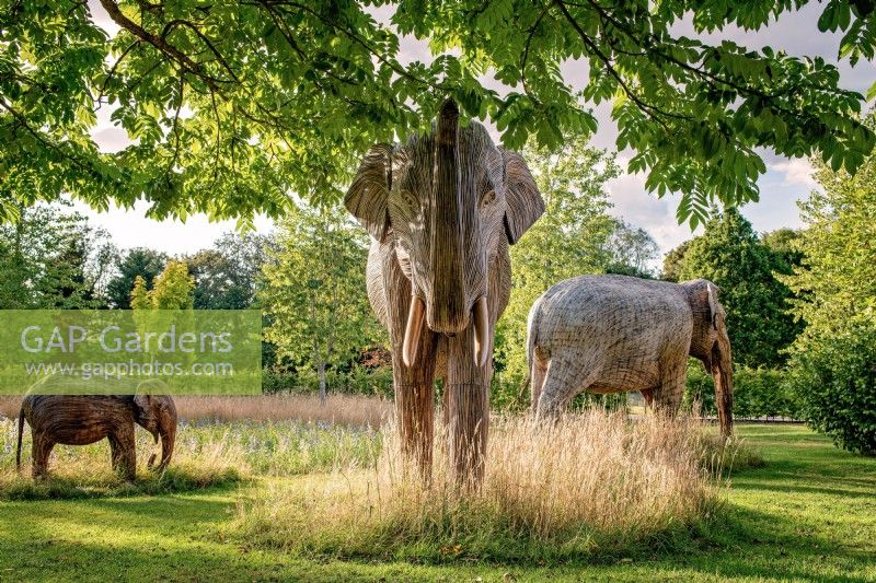 Elefantenskulpturen sitzen harmonisch auf der Orchard Room Meadow, Juli 2022.