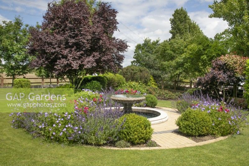 Vorgarten mit kreisförmigem Teich und Springbrunnen im New Fulfen Cottage, Lichfield, Juni