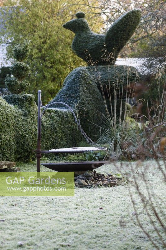 Grillen Sie im Garten des Balmoral Cottage, Kent, umgeben von Eiben- und Buchsbaumhecken und Formgehölzen