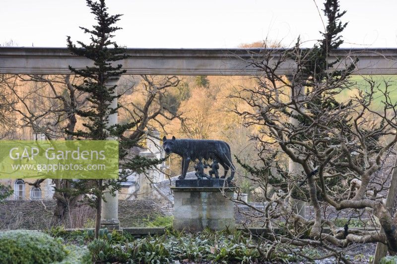 Statue von Romulus und Remus, die vom Wolf gesäugt werden, eingerahmt von der Kolonnade auf der Großen Terrasse im Iford Manor im Januar 