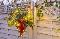 Immergrüner Weihnachts-Hängekorb mit Lichterketten beleuchtet